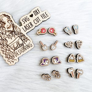 May include: A wooden cutout of a woman with curly hair, holding a sign that says "SVG ♥ DXF LASER CUT FILE Shelby DESIGNING". The image also shows a set of 10 pairs of wooden earrings with various designs, including paint brushes, hammers, nails, and a paint can.