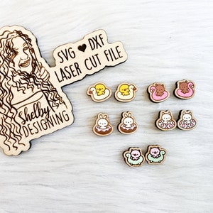 May include: A set of laser cut wooden charms featuring various animals in inflatable pool floats. The charms include a duck, a bear, a bunny, a cat, and a pig. The charms are designed for crafting projects and are available in SVG and DXF file formats. The text "SVG ♥ DXF LASER CUT FILE" is visible on the image.