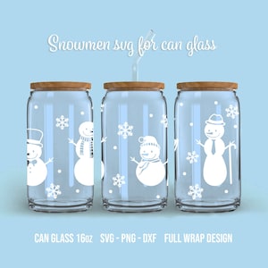Puede incluir: Tres vasos de cristal transparente en forma de lata con tapas de madera y diseños de muñecos de nieve blancos. Los muñecos de nieve llevan sombreros, bufandas y uno tiene un bastón. El texto "CAN GLASS 16oz SVG-PNG-DXF FULL WRAP DESIGN" está en la parte inferior de la imagen.
