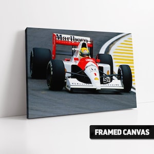 May include: A red, white, and black Formula One race car with the Marlboro logo on the side. The car is on a race track with yellow lines.