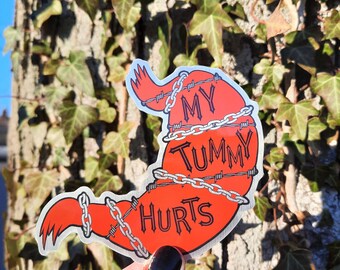 May include: A red stomach shaped sticker with a chain and barbed wire around it. The sticker says "My Tummy Hurts".