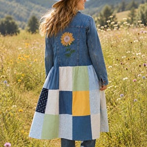 May include: A long denim jacket featuring a sunflower embroidery on the upper back and a lower section constructed from a patchwork of various blue, yellow, green, and white fabrics in floral, gingham, and polka dot patterns with long sleeves.
