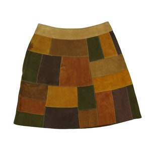 May include: A brown suede mini skirt with a patchwork design featuring various shades of brown, green, and tan.