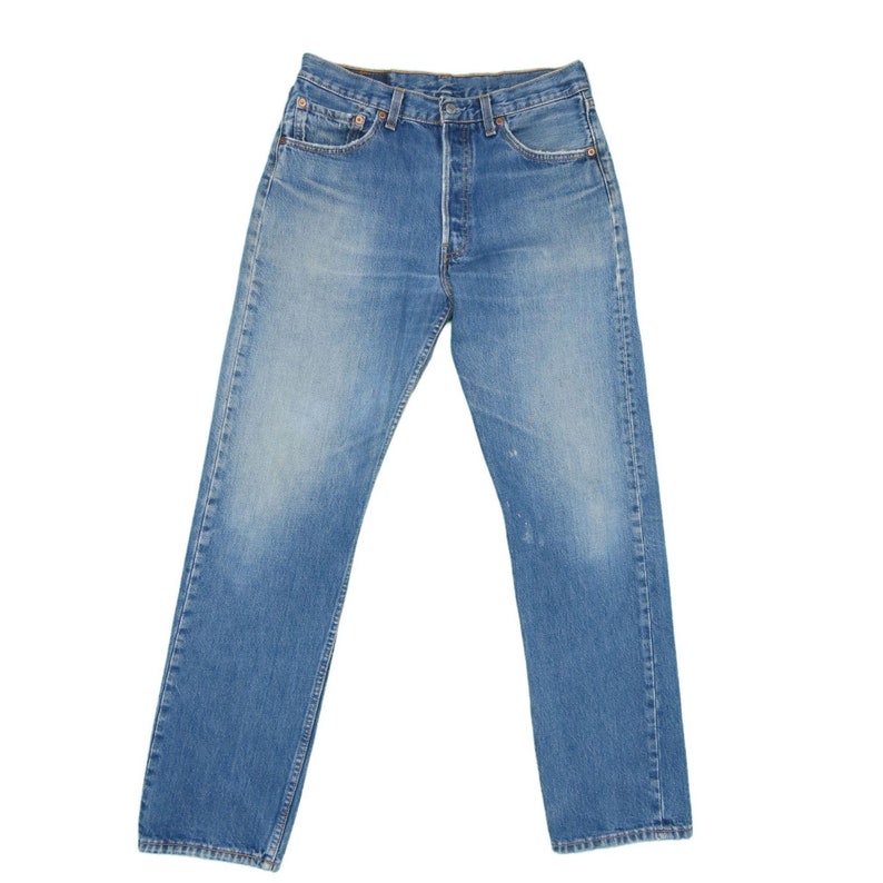 May include: A pair of blue denim jeans with a classic straight leg fit. The jeans have a button fly and five pockets.