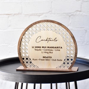 Semi circle shape bar menu standing sign made using layered Baltic birch plywood. Laser cut can rattan pattern border around the perimeter. Raised solid wood border in stained color of choice. Center area can be laser engraved with customized text.