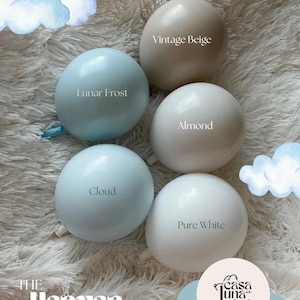 May include: Five balloons in shades of white, beige, and blue are arranged on a fluffy white surface. Each balloon is labeled with a color name: "Vintage Beige", "Lunar Frost", "Cloud", "Almond", and "Pure White". The text "The Heaven Collection" is at the bottom.