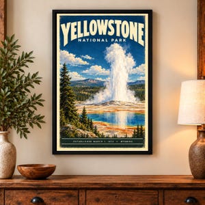 May include: A framed vertical wall art print featuring a landscape illustration of Yellowstone National Park. The image displays a large geyser erupting with white steam against a blue sky, a blue thermal pool, pine trees, and the text Yellowstone National Park, Established March 1, 1872, Wyoming.