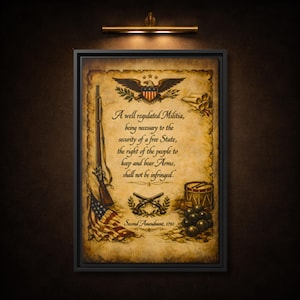 May include: Framed print featuring the Second Amendment of the U.S. Constitution. The artwork includes an eagle, a rifle, an American flag, crossed muskets, a drum, and cannonballs, all set against a parchment-style background. The text reads: "A well regulated Militia...shall not be infringed."