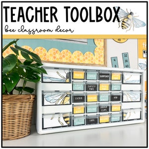 May include: White drawer organizer with clear plastic drawers labeled with bee-themed labels. The labels include words like "Mints", "Chalk", "Safety Pins", "Push Pins", "Extra Erasers", "Binder Rings", "Lap Buds", "Hot Glue Sticks", "Tape", "Batteries", and "Magnets".