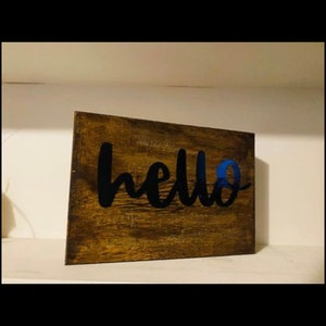以下が含まれることがあります： 黒い塗料で「hello」と書かれた木製の看板です。