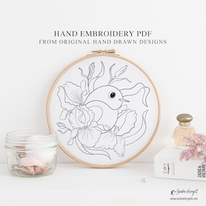 May include: A hand embroidery PDF design featuring a bird and floral motif, displayed in a wooden hoop. The design is outlined in dark blue on a white background. Text on the image reads "HAND EMBROIDERY PDF FROM ORIGINAL HAND DRAWN DESIGNS".