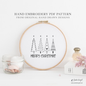 May include: A hand embroidery PDF pattern in a wooden hoop. The design features four stylized Christmas trees and the words "MERRY CHRISTMAS" in black. The text "HAND EMBROIDERY PDF PATTERN FROM ORIGINAL HAND DRAWN DESIGNS" is at the top.