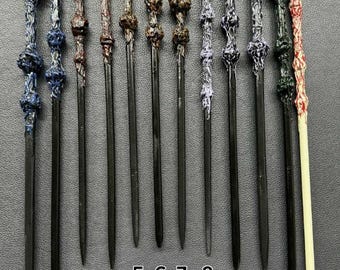 May include: A collection of twelve intricately designed wands, each with a unique handle and dark, slender shaft. The handles feature various colors and textures, including blue, brown, and purple, with detailed carvings. The wands are arranged vertically against a dark background.