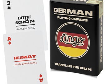 May include: A black metal tin labeled GERMAN PLAYING CARDS and TRANSLATE THE FUN with a circular German flag graphic and the word Lingo. Two white playing cards are shown: one with a spade, 3, and BITTE SCHÖN, and one with a diamond, A, and HEIMAT.