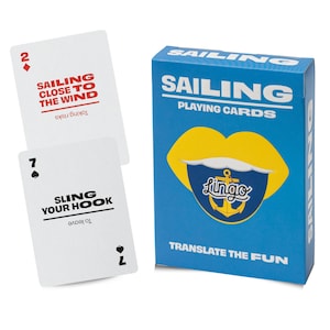 May include: A blue deck of Sailing Playing Cards featuring a yellow lip graphic and anchor logo. The box reads Sailing Playing Cards and Translate the Fun. Two white cards are shown: one with a red 2 of diamonds and text Sailing Close to the Wind.
