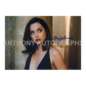 Könnte beinhalten: Ein Foto einer Frau mit dunklem Haar und rotem Lippenstift, die ein schwarzes Kleid und eine silberne Halskette trägt. Das Bild enthält den Text "Anthony Autographs" und eine Unterschrift.