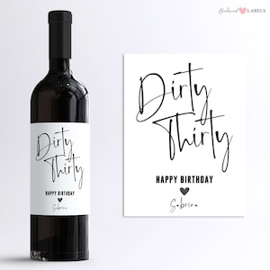 May include: A white wine bottle label with black text that reads "Dirty Thirty Happy Birthday Sabrina". A black heart is next to the text "Happy Birthday".