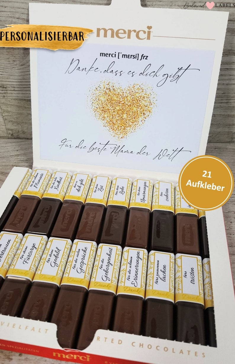 May include: A box of assorted chocolate bars with personalized labels. The labels feature a variety of messages, including "For the best Mom in the world", "For your patience", "For your love", and "For your hugs". The box is decorated with a gold heart and the word "merci".