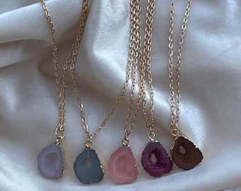 May include: Five gold chain necklaces with different colored agate stone pendants. The pendants are in shades of purple, blue, pink, and red.