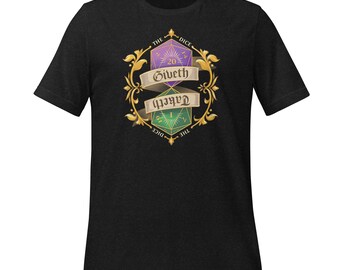 Könnte beinhalten: Schwarzes T-Shirt mit einer Grafik von zwei Würfeln, einem lila und einem grünen, und dem Text "The Dice Giveth Taketh". Das Design ist von goldenen Filigranarbeiten umrahmt. Das T-Shirt ist aus einem weichen Material.