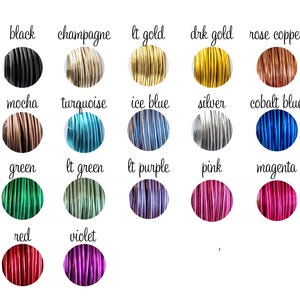 Op de afbeelding: Een verzameling gekleurde draadspoelen, elk gelabeld met een kleurnaam. Kleuren zijn onder meer zwart, champagne, lichtgoud, donkergoud, rozenkoper, mokka, turquoise, ijsblauw, zilver, kobaltblauw, groen, lichtgroen, lichtpaars, roze, magenta, rood en violet.