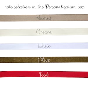 May include: A selection of satin ribbons in various colors, including Humus, Cream, White, Olive, and Red. The text "note selection in the Personalization box" is at the top. Each ribbon is labeled with its color name in a cursive font.