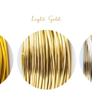 Op de afbeelding: Close-up van drie cirkelvormige displays van goudkleurige draad in verschillende tinten. De tekst boven elke cirkel luidt "Dark Gold", "Light Gold" en "Champagne". De draad is strak opgerold en toont de verschillende metallic tinten.