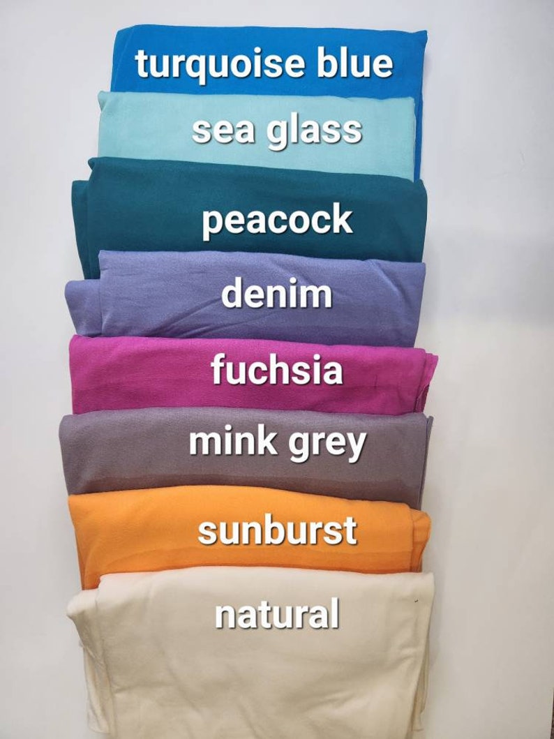 May include: A stack of eight fabric swatches in different colors, including turquoise blue, sea glass, peacock, denim, fuchsia, mink grey, sunburst, and natural.
