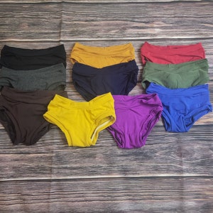 May include: Ten pairs of underwear in various colors, including black, gray, brown, yellow, blue, purple, red, and green. The underwear is made of a soft, stretchy fabric and has a comfortable fit.