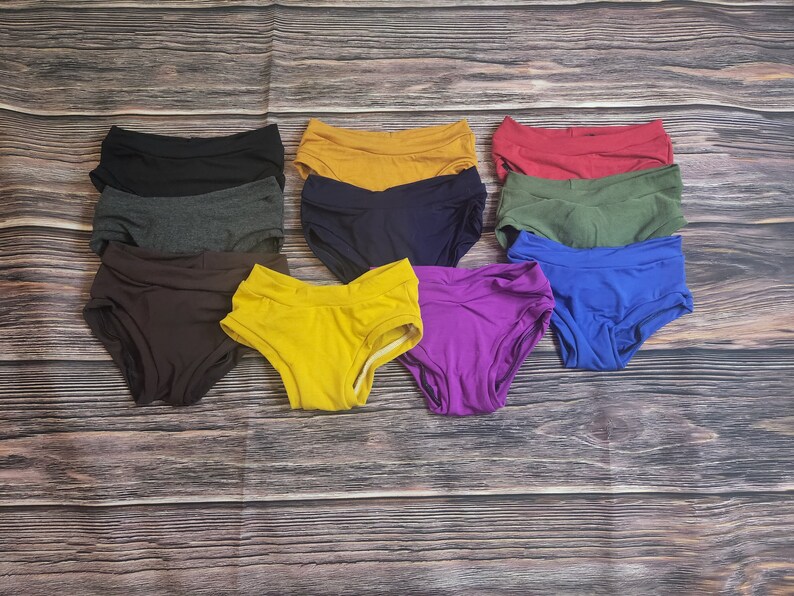 May include: Ten pairs of underwear in various colors, including black, gray, brown, yellow, blue, purple, red, and green. The underwear is made of a soft, stretchy fabric and has a comfortable fit.