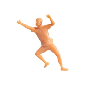 May include: A small plastic figurine of a person in a running pose with arms raised. The figurine is a light peach colour.