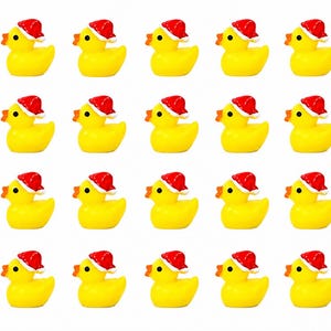 Puede incluir: Una colección de veinte patitos de goma amarillos, cada uno con un pequeño gorro de Papá Noel rojo con ribete blanco. Los patos tienen picos naranjas y ojos negros, creando un tema festivo navideño.