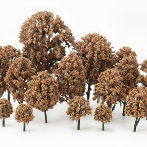 May include: A collection of miniature model trees with brown foliage and black trunks. The trees vary in size, creating a diverse forest scene. Ideal for model train layouts, dioramas, or craft projects.