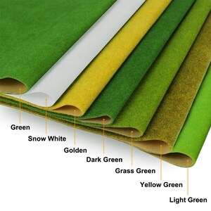 以下が含まれることがあります： Green、Snow White、Golden、Dark Green、Grass Green、Yellow Green、Light Greenとラベル付けされた、様々な色のテクスチャ加工されたクラフト素材のシート7枚が重なっています。各シートは柔らかく繊維質な表面の質感をしています。