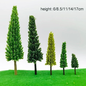 May include: A collection of miniature artificial trees in varying shades of green. The trees range in height from 6 cm to 17 cm. The trees are set on a green surface, with a white background. The text "height: 6/8.5/11/14/17cm" is visible.