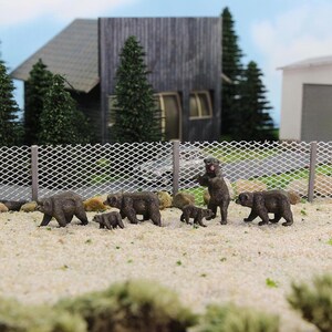 Pu&ograve; includere: Un gruppo di figurine di orsi bruni, tra cui una mamma orsa e i suoi cuccioli, in piedi dietro una recinzione di filo metallico. Gli orsi sono tutti rivolti in avanti e la mamma orsa &egrave; in piedi sulle zampe posteriori.
