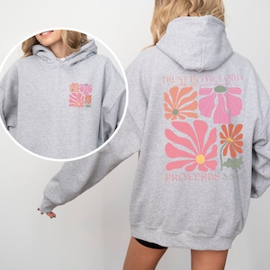 May include: Grey hooded sweatshirt with a floral design and the text "TRUST IN THE LORD WITH ALL YOUR HEART" and "PROVERBS 3:5-6" on the back.