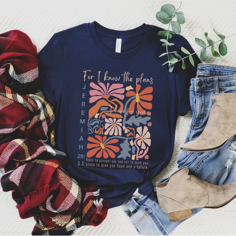 May include: Navy blue t-shirt with a floral design and the text "For I know the plans I have for you" and a bible verse from Jeremiah 29:11.