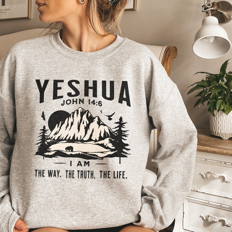 May include: Grey sweatshirt with a black mountain scene graphic and the text "YESHUA JOHN 14:6 I AM THE WAY. THE TRUTH. THE LIFE."