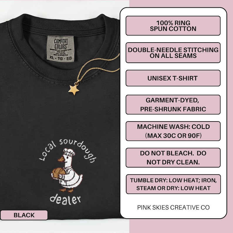 Puede incluir: Camiseta unisex negra con un dise&ntilde;o bordado en blanco de un pato chef sosteniendo pan, y las palabras "Local sourdough dealer". La camiseta tiene un collar de estrella dorada. Hecha de algod&oacute;n 100% hilado en anillo.