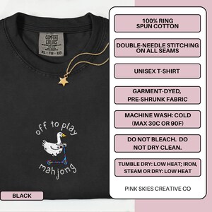 May include: Black unisex t-shirt with embroidered design. The design features a white duck on a scooter with the words "off to play mahjong". The shirt is made of 100% ring spun cotton and has double-needle stitching on all seams.