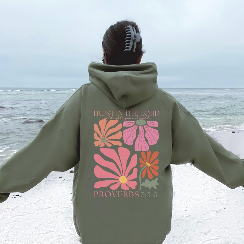 May include: A green hooded sweatshirt with a floral design and the text "TRUST IN THE LORD with all your heart" and "PROVERBS 3:5-6" on the back.