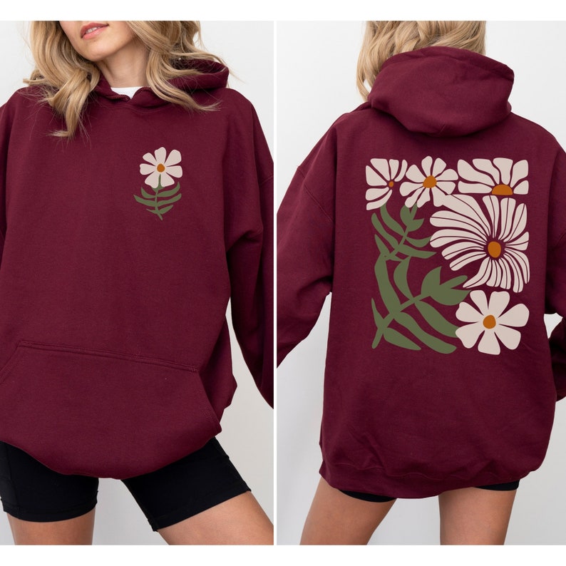 Puede incluir: Sudadera con capucha color burdeos con un dise&ntilde;o floral en la espalda y un dise&ntilde;o floral m&aacute;s peque&ntilde;o en la parte delantera. La sudadera tiene una capucha con cord&oacute;n y un bolsillo canguro.