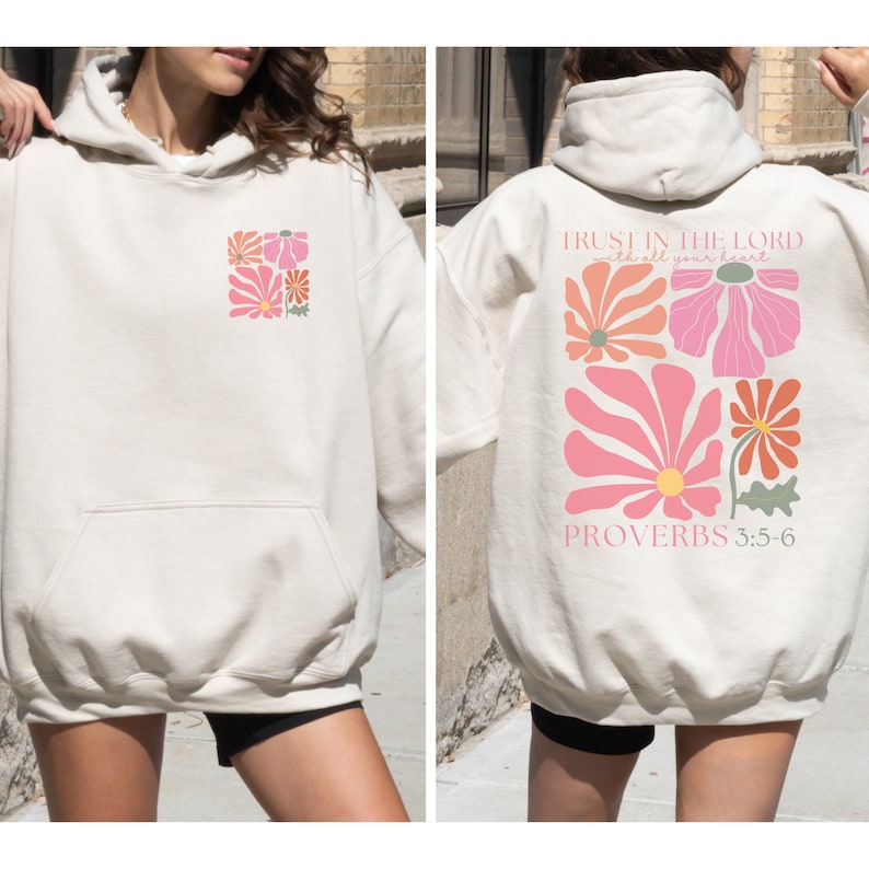 May include: A cream-coloured hoodie with a floral design on the front and the text "TRUST IN THE LORD with all your heart" and "PROVERBS 3:5-6" on the back.