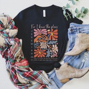 May include: Black t-shirt with a floral design and the text "For I know the plans I have for you" with the scripture reference Jeremiah 29:11. The text reads "Plans to prosper you and not to harm you, plans to give you hope and a future."