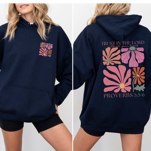 May include: Navy blue hoodie with a floral design and the text "TRUST IN THE LORD with all your heart" and "PROVERBS 3:5-6" on the back.