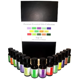 May include: A set of 14 small glass bottles filled with essential oils. The bottles are arranged in a semi-circle on a white background. The bottles are labelled with the names of the oils, including Lavender, Eucalyptus, Sage, Peppermint, and Lemon. The bottles are all black with a silver cap. A black box with the text "Premium Essential Oils Collection" and "Top 14" is behind the bottles.