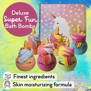 May include: Six colourful bath bombs shaped like unicorns with gold horns. The bath bombs are arranged in a semi-circle. The text "Deluxe Super Fun Bath Bombs" is at the top of the image. The text "Finest ingredients" and "Skin moisturising formula" are at the bottom of the image.