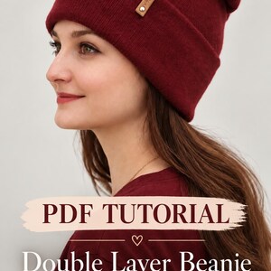 May include: A deep red knitted beanie with a folded brim and a small rectangular tan leather tag featuring the text V-FRANZ. The image includes the text PDF TUTORIAL Double Layer Beanie with Folded Brim overlaid on the lower portion of the frame.
