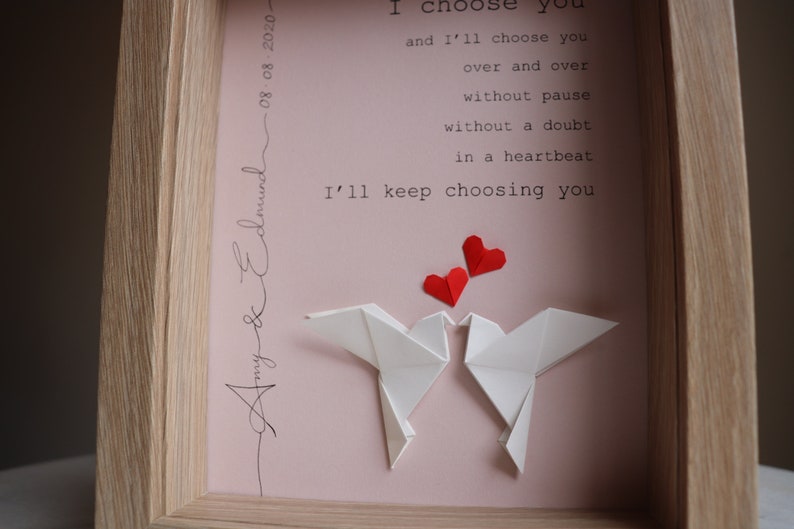 May include: A framed print with a pink background and white origami doves. The print features the text "I choose you and I'll choose you over and over without pause without a doubt in a heartbeat I'll keep choosing you."  The print is signed "Amy & Edmund 08-08-2020".